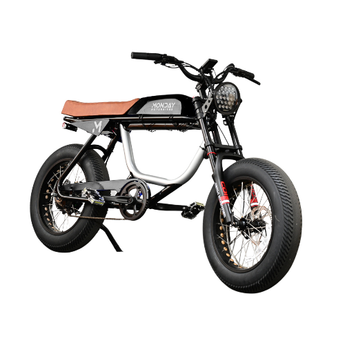 ANZA 1KW SR electric cafe racer motorcycle featuring black and silver frame, brown leather seat, fat tires, high-rise handlebars, and distinctive LED headlight, shown in side profile against white background