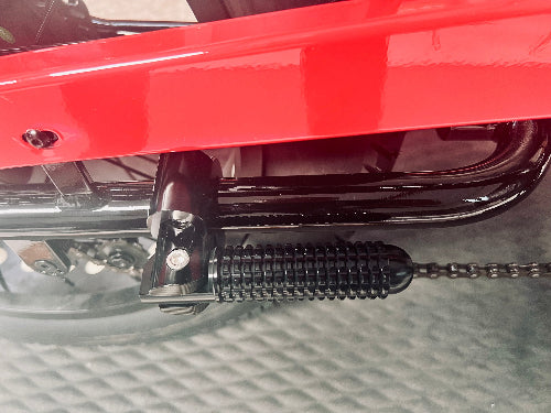 A close-up view of the ANZA footpeg in its folded position, attached to the e-bike frame.